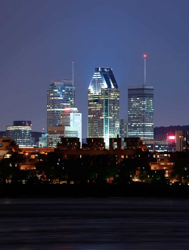 Montreal over river at dusk with city lights and urban buildings